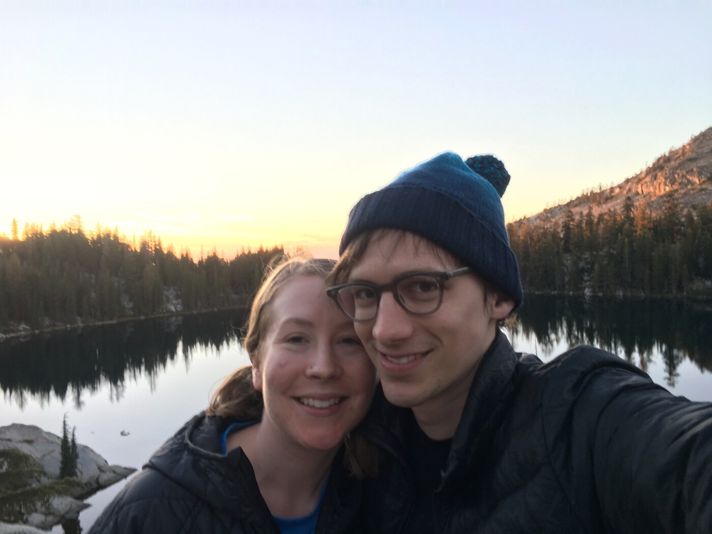 photo of celeste and phil hugging with a mountain lake behind them